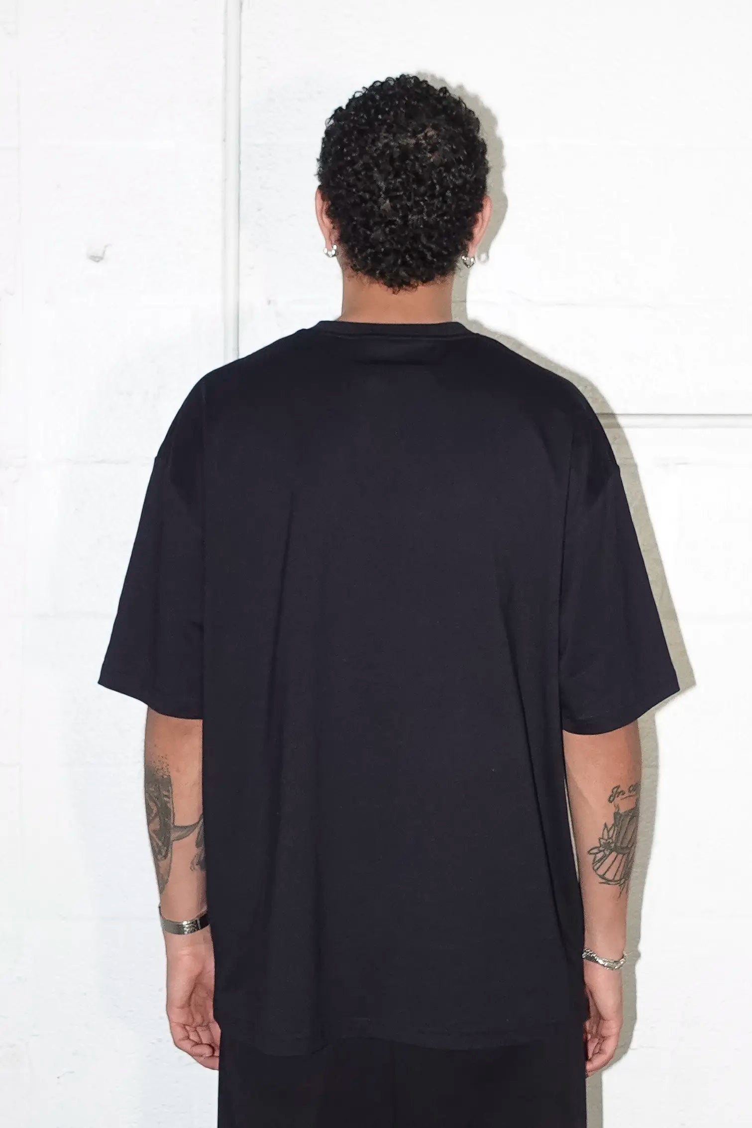 Person wearing a black t-shirt with a white background