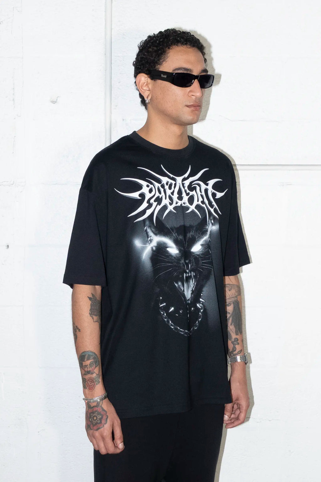 Person wearing a black t-shirt with a Parasite Label screaming punk cat graphic design and text against a white background