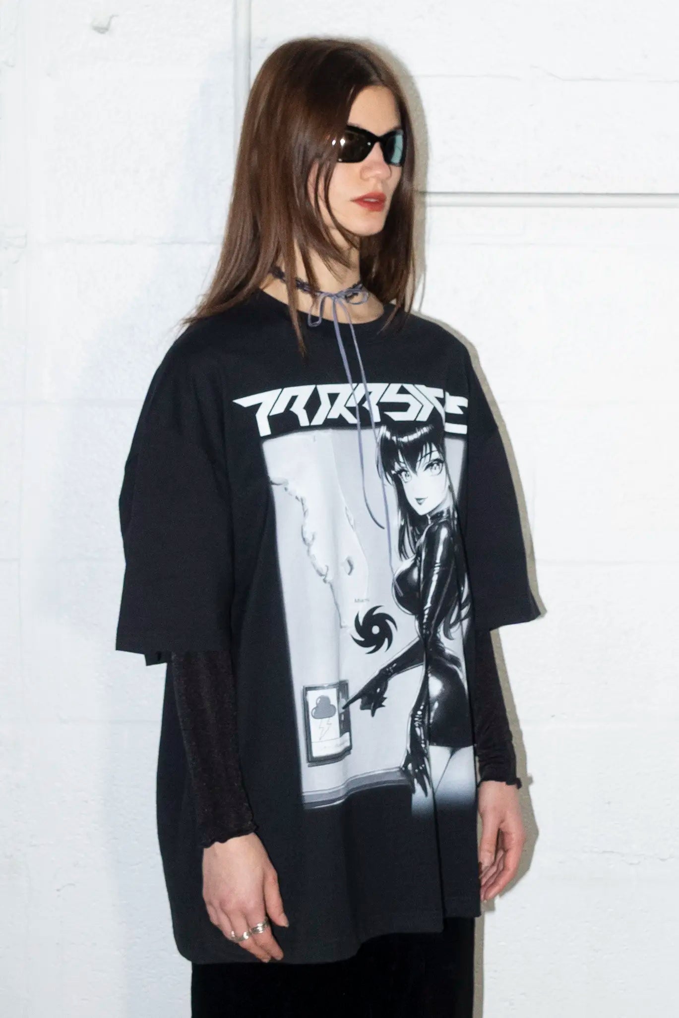 Person wearing oversized black t-shirt with a Parasite Label graphic design and text, standing against a white background