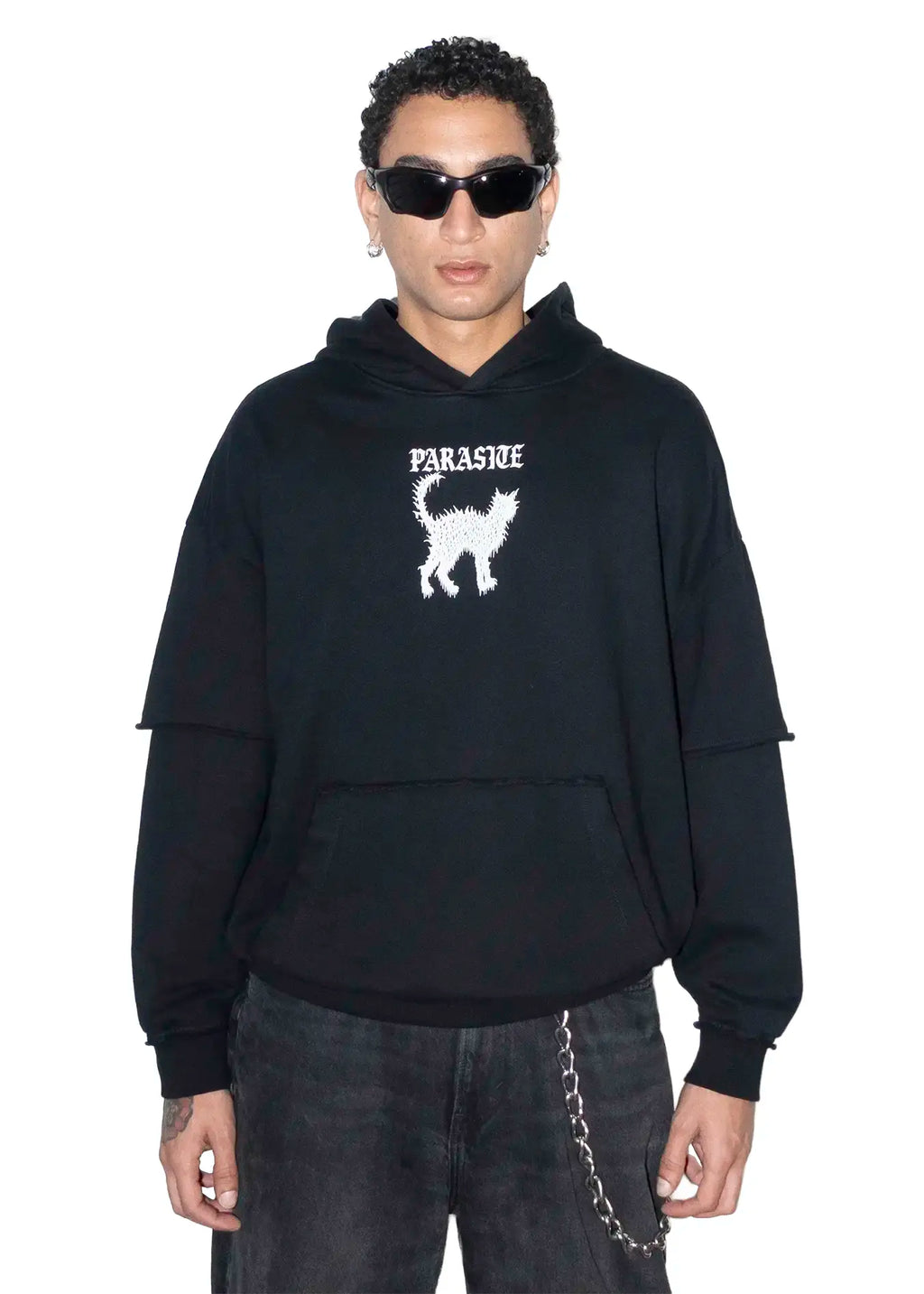 Person wearing a black hoodie with Parasite Label and cat graphic design on a white background